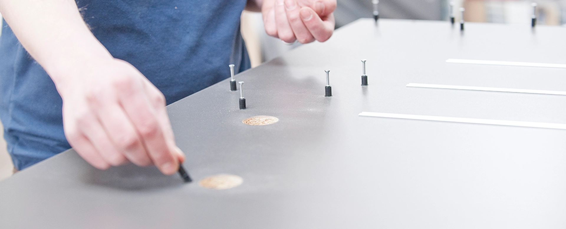 Produktionshelfer bei der Montage von Möbelteilen